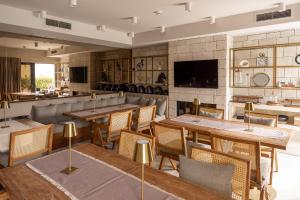 a restaurant with tables and chairs and a television at Mamei Boutique Villa in Dobrota
