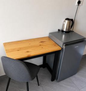 a desk with a tea kettle on it next to a chair at 60 On Kosmos in Bellville South