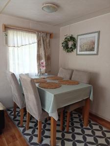 a dining room table with chairs and a green tablecloth at Chatka in Nasutów