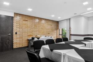 a conference room with tables and chairs and a brick wall at Cafe Hotel Medellín in Medellín +77 photos