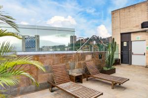 two chairs on a balcony with a view of the city at Cafe Hotel Medellín in Medellín