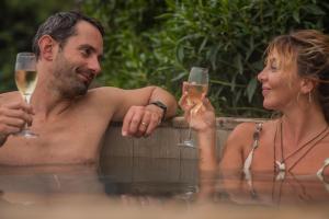 a man and a woman sitting in a bath tub with wine glasses at Hotel Mae in Maitencillo