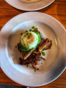 a plate of food with an egg and bacon at AsiaTica Lodge Volcano and Lake View in El Castillo de La Fortuna
