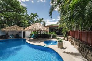 a swimming pool with a patio and a house at Coco Garden Suites in Coco