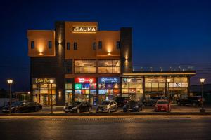 a building with cars parked in a parking lot at night at The Alima Suites in Accra