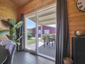 a glass door leading to a patio with a table at Country Holiday home with shared pool in Someren-Heide