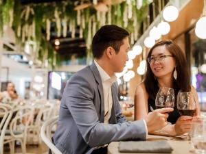 a man and woman sitting at a table with wine glasses at Pullman Brisbane King George Square in Brisbane