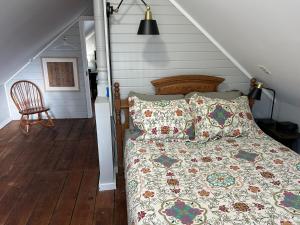 a bed with a quilt on it in a room at Quaco Cottages-The Shipbuilder's Summer Kitchen in Saint Martins