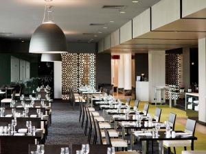a dining room filled with tables and chairs at Mercure Melbourne Albert Park in Melbourne