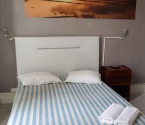 a bedroom with a bed with two towels on it at Residencial Moderna in Figueira da Foz
