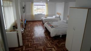 a hotel room with two beds and a window at Casa jardín Roqui in Puno