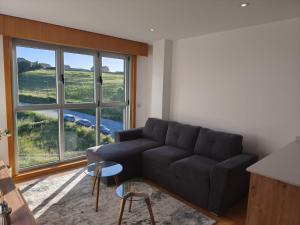 a living room with a couch and a large window at Brisas de Malpica in Malpica