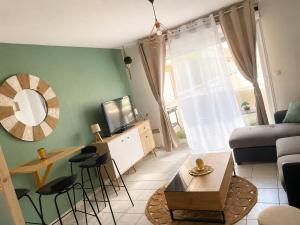 a living room with a couch and a tv at Studio cosy climatisé avec piscine parking Centre de Brignoles in Brignoles