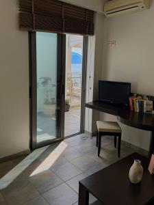 a room with a desk and a view of a patio at Gonis Suites in Palaiochora