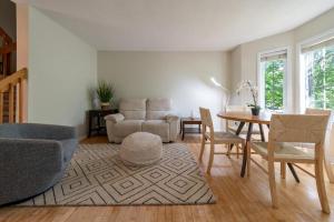 a living room with a couch and a table and chairs at Pool, BBQ & Foosball Spacious 4BR Home in Gatineau