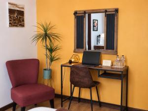 a room with a desk with a laptop and two chairs at Casa do Criativo ® Bed&Breakfast in Almada