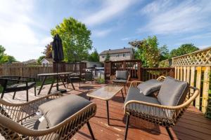 a patio with wicker chairs and tables on a deck at Pool, BBQ & Foosball Spacious 4BR Home in Gatineau