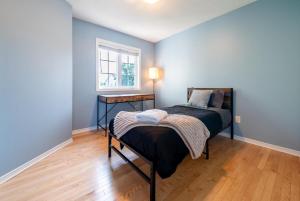 a bedroom with blue walls and a bed with a table at Pool, BBQ & Foosball Spacious 4BR Home in Gatineau +27 photos