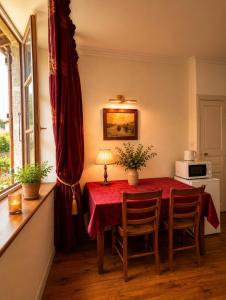 a dining room with a red table and chairs at Chez Vanessa Entrée privée avec escalier in Saint-Gervais-dʼAuvergne