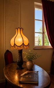 a lamp sitting on top of a table with a book at Chez Vanessa Entrée privée avec escalier in Saint-Gervais-dʼAuvergne