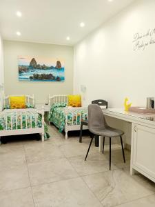 a room with two beds and a desk and a table at Al Punto Giusto in Catania