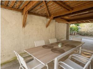 a wooden table with white chairs and a wooden ceiling at Maison de vacances in Capdenac-Gare