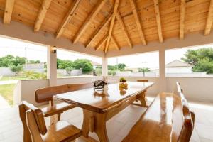 a dining room with a wooden table and chairs at Villa Zrilic with Private Pool in Benkovac