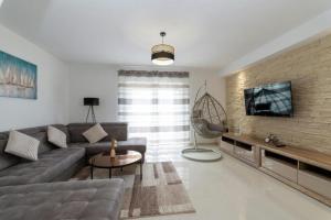 a living room with a couch and a tv on a brick wall at Villa Zrilic with Private Pool in Benkovac