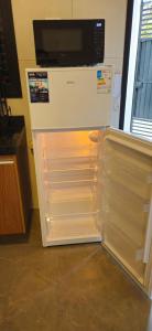a refrigerator with its door open in a kitchen at Loft 7 com ar-condicionado da Rede Urbana in Indaiatuba