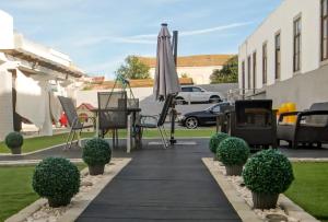 a patio with an umbrella and chairs and plants at Residencial Moderna in Figueira da Foz