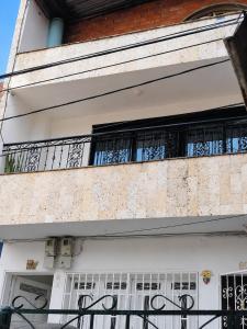 a building with white doors and a balcony at Morada Living Bello HomeStay in Bello +3 photos