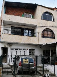 a building with a car parked in front of it at Morada Living Bello HomeStay in Bello