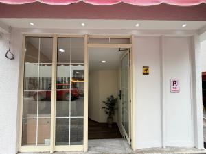 a glass door to a building with a red car in it at EDEAN Apartments 4 in Tirana