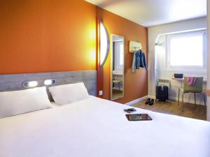 a bedroom with a bed and a desk and a window at ibis budget Vienne Sud in Vienne