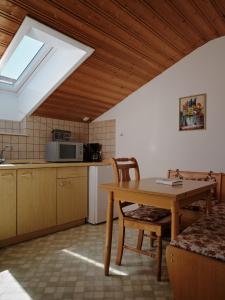 a kitchen with a table and a sink and a window at Gschwingerhof in Riedering