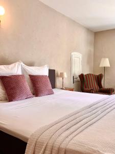 a bedroom with a large white bed with red pillows at Le Moulin de Montségur in Montségur-sur-Lauzon +61 photos