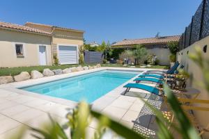 a swimming pool with chairs next to a house at Olympe de Provence in Caromb