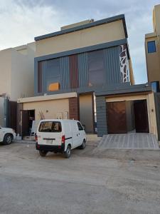 a white van parked in front of a building at فيلا مكونة من 3 غرف نوم و مجلس و صالة و مطبخ وغرفة عاملة و مسبح تفتح الغرف حسب عدد النزلاء in Riyadh