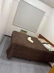 a bed with a teddy bear laying on top of it at Apartamento, Campos dos Goytacazes, centro in Campos dos Goytacazes