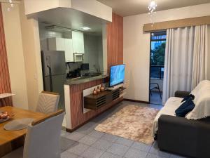 a living room with a television and a kitchen at Apartamento, Campos dos Goytacazes, centro in Campos dos Goytacazes