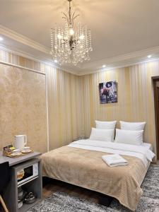 a bedroom with a large bed and a chandelier at Stefan 64 in Chişinău