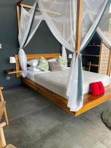 a bedroom with a bed with a mosquito net at AsiaTica Lodge Volcano and Lake View in El Castillo de La Fortuna