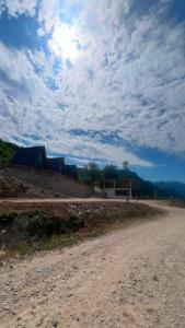 a dirt road with a building and a cloudy sky at Bujtina Panorama Kir in Kashec