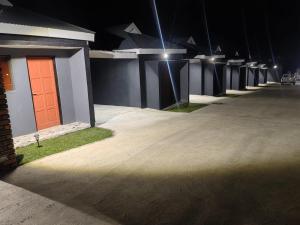a row of houses with a red door at night at Qten Camp in Pietermaritzburg +7 photos