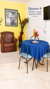a blue table with two chairs and a couch at Pousada das Estrelas - Centro de Conservatória - rua principal in Conservatória