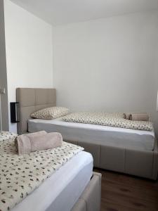 two beds sitting next to each other in a room at Apartman Tomislav in Slavonski Brod
