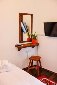 a bedroom with a bed and a mirror and a stool at Sokak Boutique Hotel in Berat