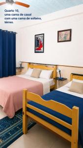 two beds in a hotel room with a sign that reads orange cannot die at Pousada das Estrelas - Centro de Conservatória - rua principal in Conservatória +33 photos