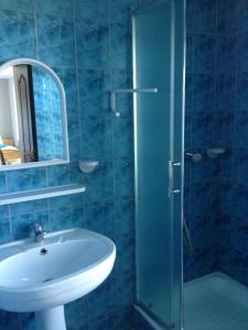 a bathroom with a sink and a glass shower at Noclegi Beata in Dąbki