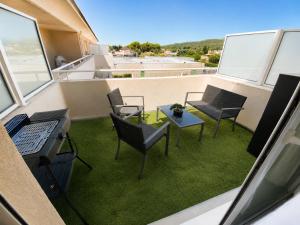 a balcony with chairs and a desk and a table at Studio cosy climatisé avec piscine parking Centre de Brignoles in Brignoles